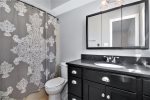 Primary ensuite bathroom has a large vanity and a shower tub combo